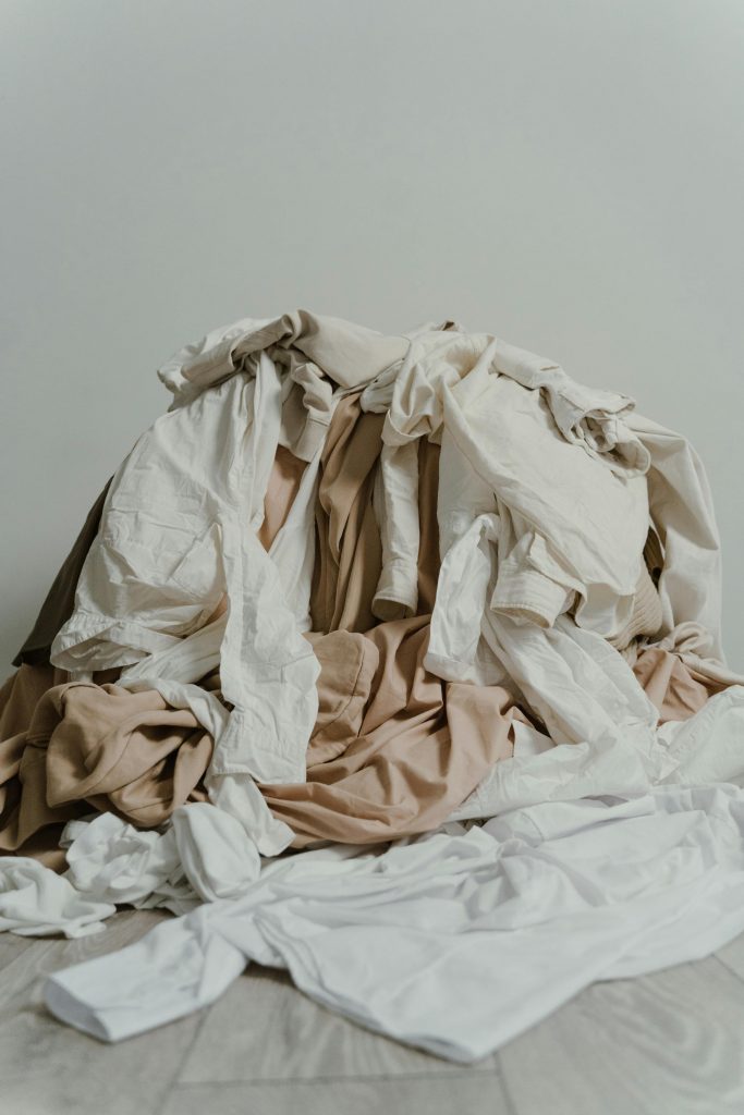 Pile of clothes on bed. Ready to tidy.
